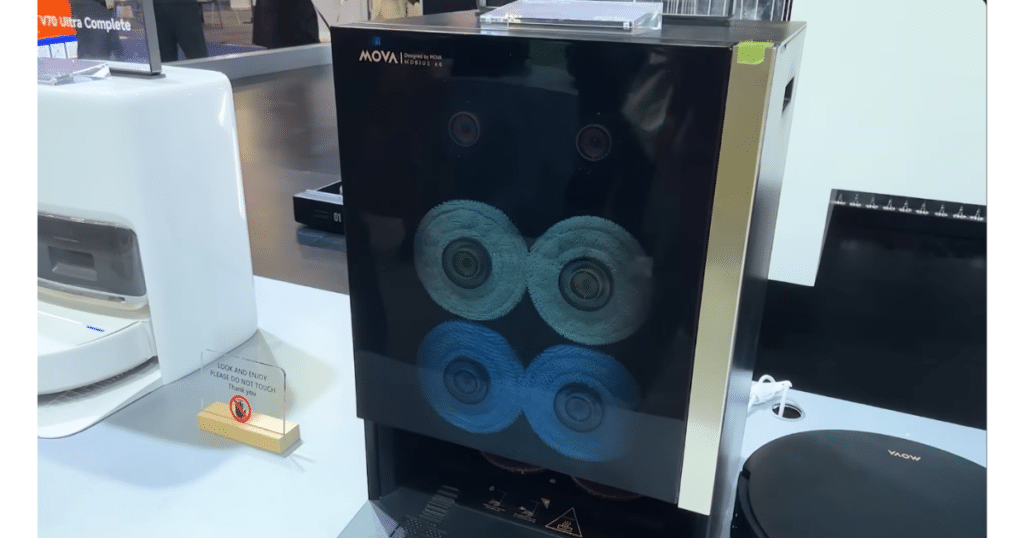 MOVA Mobius 60 at CES 2026 | Vacuum Wars MOVA Mobius 60 robot vacuum and mop displayed at CES, showing three interchangeable mop pads inside the docking station.