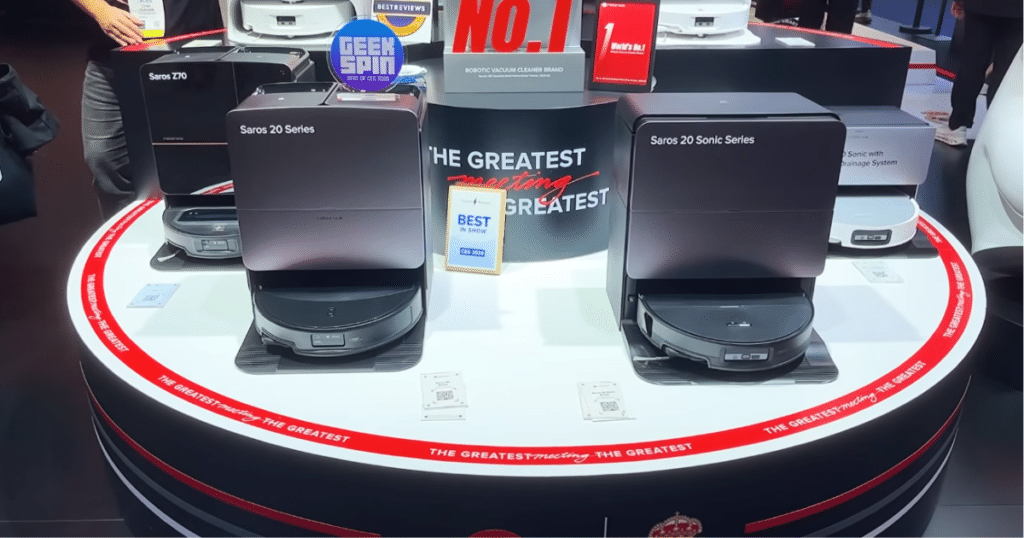 Roborock Saros 20 at CES 2026 | Vacuum Wars Roborock Saros 20 and Saros 20 Sonic robot vacuums displayed on a circular showroom platform at a product unveiling event.