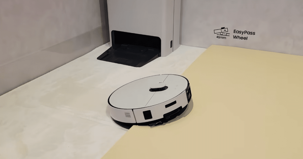 Samsung Bespoke AI Jet Bot Steam Ultra at CES 2026 | Vacuum Wars Samsung Bespoke AI JetBot Steam Ultra robot vacuum navigating a threshold near its docking station during a CES demonstration.