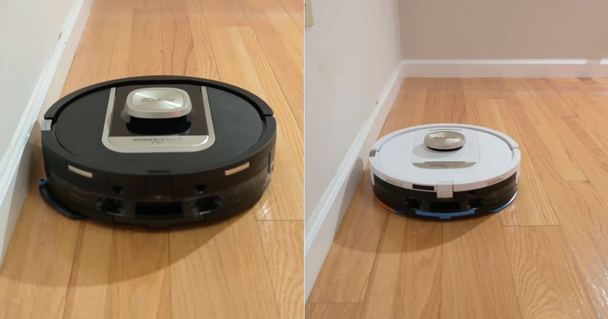 | Vacuum Wars Split image showing the Shark PowerDetect NeverTouch Pro in black on the left and the Shark PowerDetect ThermaCharged NeverTouch Pro in white on the right, each positioned near a baseboard on hardwood to assess wall and edge coverage.