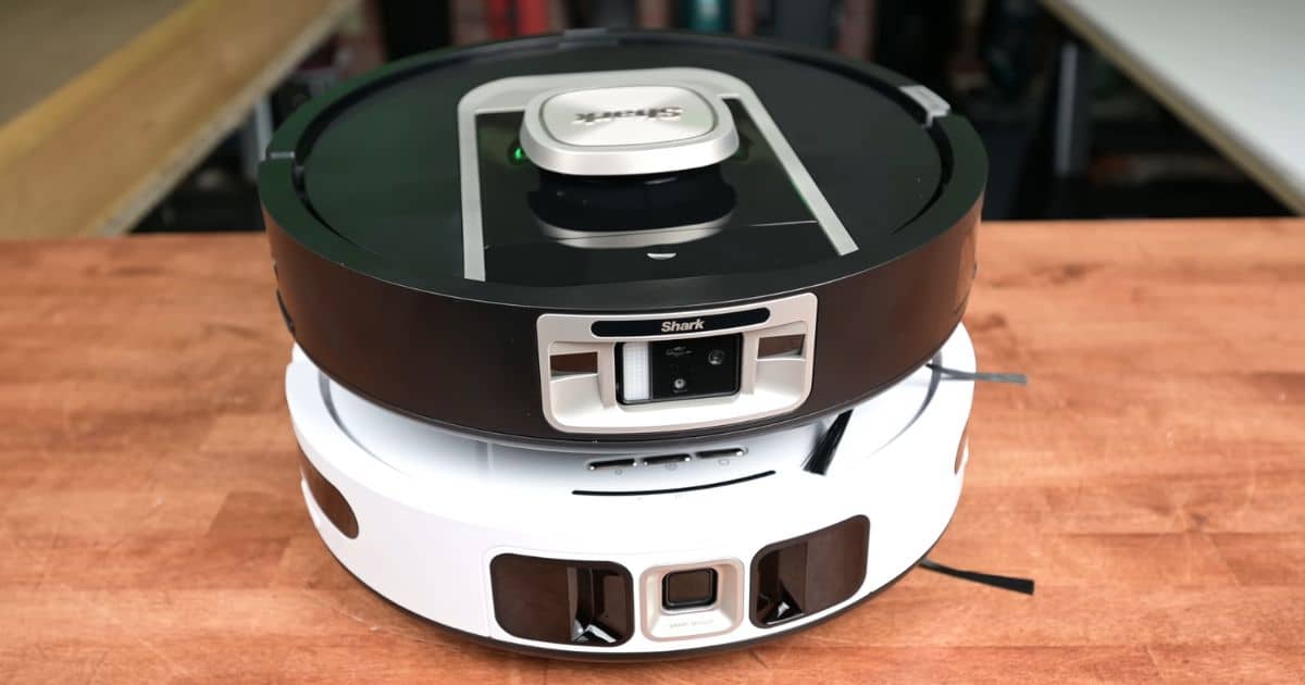 | Vacuum Wars The black Shark PowerDetect NeverTouch Pro stacked on top of the white Shark PowerDetect ThermaCharged NeverTouch Pro on a tabletop, showing their front sensor areas and overall body shape.