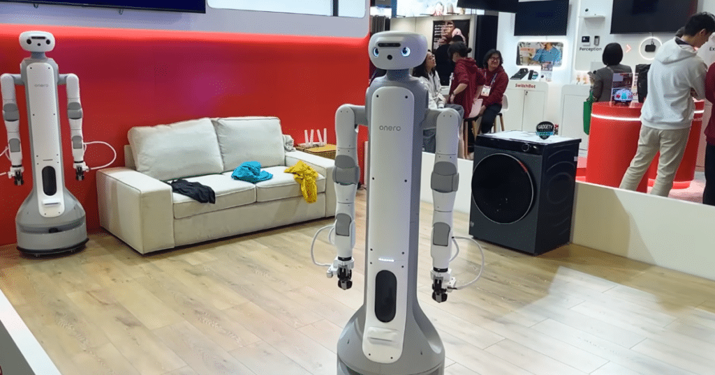 Switchbot at CES 2026 | Vacuum Wars SwitchBot Onero H1 home-assistant robot displayed at CES, shown standing in a staged living room environment.