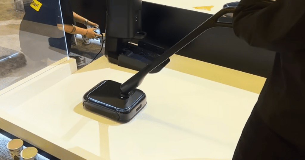 Xlean at CES 2026 | Vacuum Wars xLean TR1 floor washing robot demonstrated in manual mode with an attached handle at a CES exhibit.