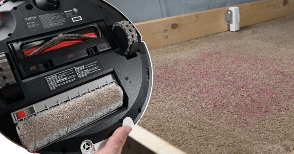 Yeedi M14 Plus Pet Hair Evaluation | Vacuum Wars Underside of the Yeedi M14+ robot vacuum after completing a pet hair evaluation, showing minimal hair wrap on the brush roll.