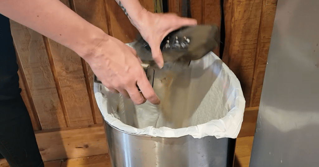 Dreame L50 Ultra Update bin issues | Vacuum Wars Emptying the Dreame L50 Ultra robot vacuum dustbin into a trash can after pet hair buildup caused clogging issues.