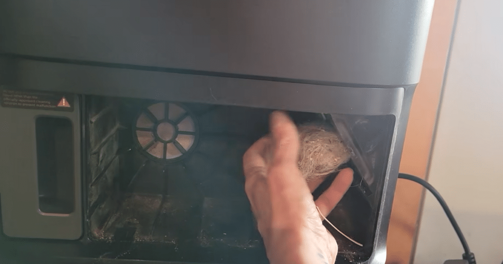 Dreame L50 Ultra Update dock clog | Vacuum Wars Clearing a pet hair clog from the Dreame L50 Ultra dock debris channel after blockage at the dustbin port.