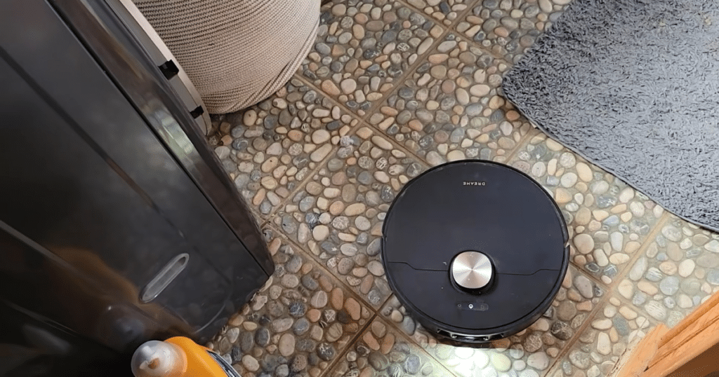 Dreame L50 Ultra Update mop bathroom | Vacuum Wars Dreame L50 Ultra robot vacuum on textured bathroom tile and bath rug, demonstrating mop detection and carpet recognition.