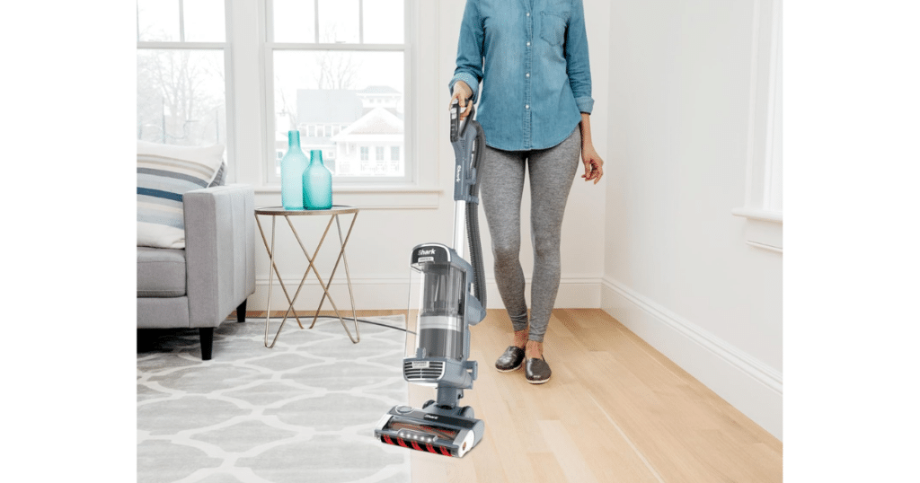 hark Performance Powered Lift-Away UV2500 upright vacuum being used on a hardwood floor in a bright living room.