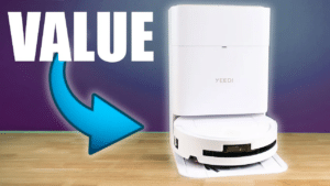 | Vacuum Wars Image with the word “VALUE” and a blue arrow pointing to the Yeedi M14 Plus robot vacuum and its dock on a tabletop.