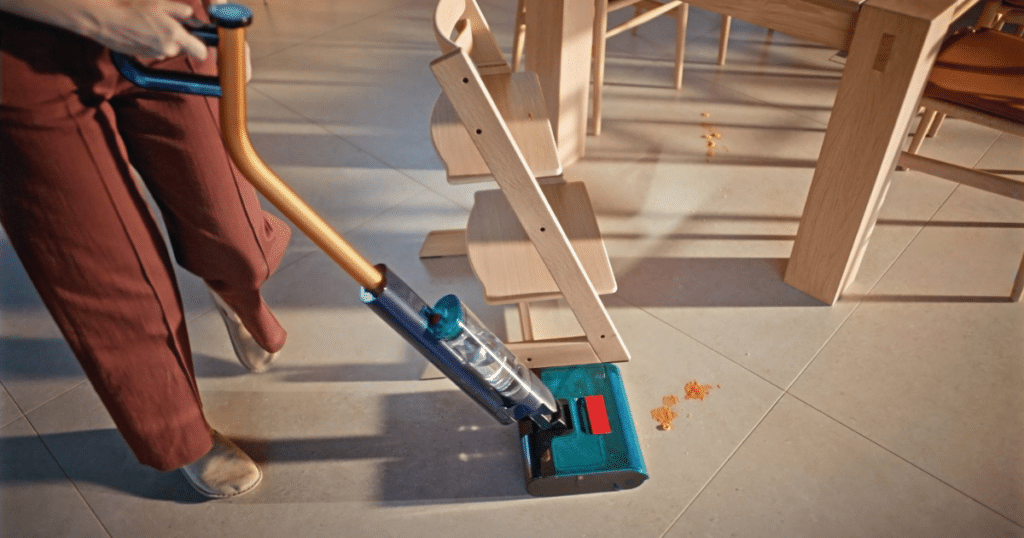 Dyson Clean Wash Hygiene Household Cleanup | Vacuum Wars Dyson Clean+Wash Hygiene cleaning dry debris on a hard floor near dining furniture