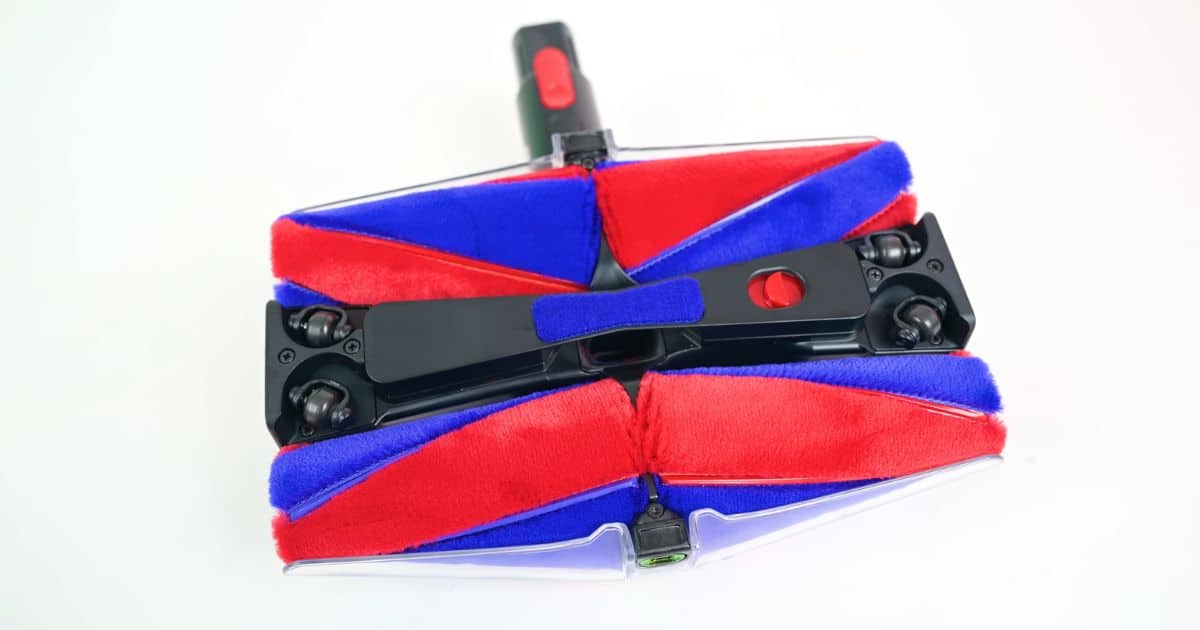 | Vacuum Wars Underside view of the Dyson Fluffycones cleaner head showing four red-and-blue conical brush bars arranged in pairs around the center suction path.