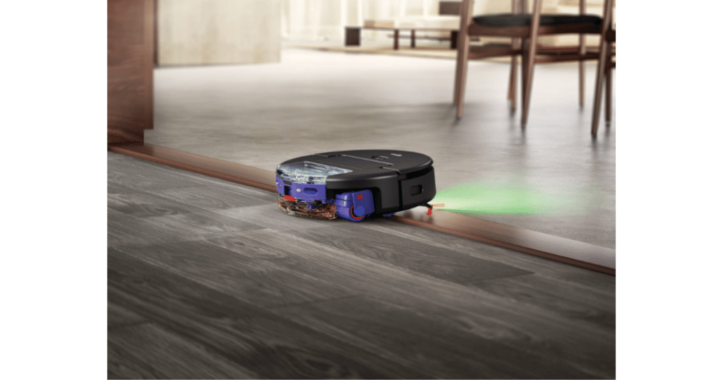 Dyson Spot and Scrub 20mm threshold | Vacuum Wars Dyson Spot+Scrub AI robot vacuum crossing a floor threshold while detecting debris with green illumination.