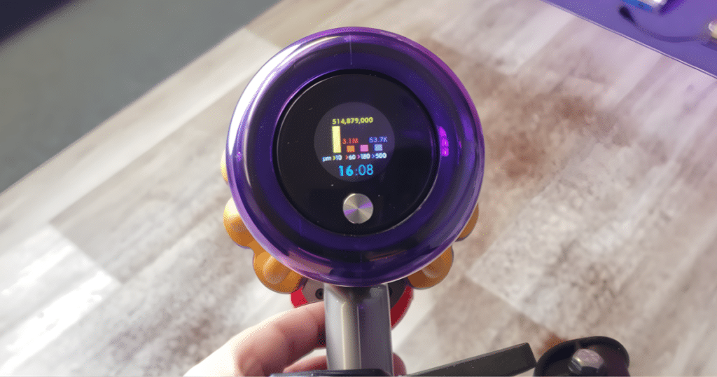 Dyson V15 LCD | Vacuum Wars Dyson V15 Detect cordless vacuum LCD screen displaying real-time particle counts and cleaning data during use