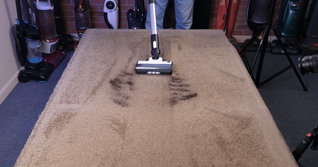 LVC 200 Carpet | Vacuum Wars The Levoit cordless Stick Vacuum vacuuming up coffee grounds from a carpeted floor