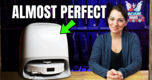 Thumbnail image for the Roborock Qrevo Curv S5X review showing the robot vacuum in its white dock beside a woman seated at a table, with the words “ALMOST PERFECT” and a green arrow pointing toward the dock.