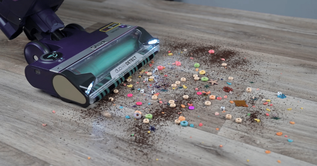 Shark PowerDetect Upright Hard floor Pickup 1 | Vacuum Wars Shark PowerDetect Upright Vacuum approaching large and small debris on a hard floor surface.