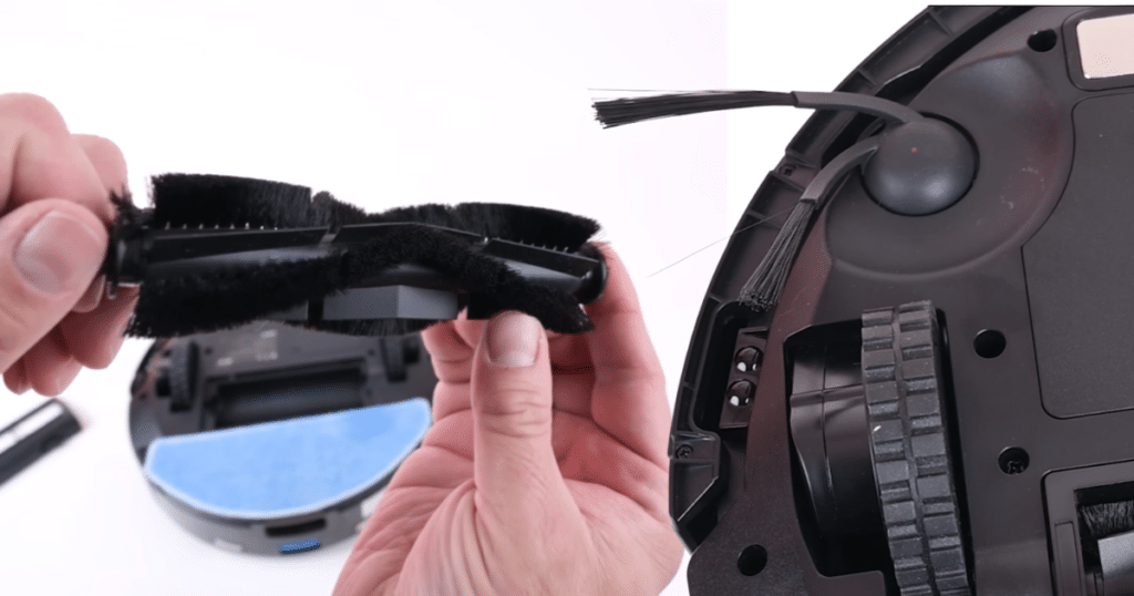 Tikom L8000 Brushes | Vacuum Wars Close-up of the Tikom L8000 Plus robot vacuum’s bristle main roller brush and fixed V-shaped side brush on the underside of the robot.