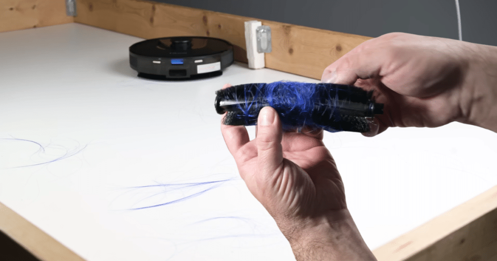 Tikom L8000 Hair Tangle | Vacuum Wars Main roller brush from the Tikom L8000 robot vacuum wrapped with long hair during a hair tangle test.