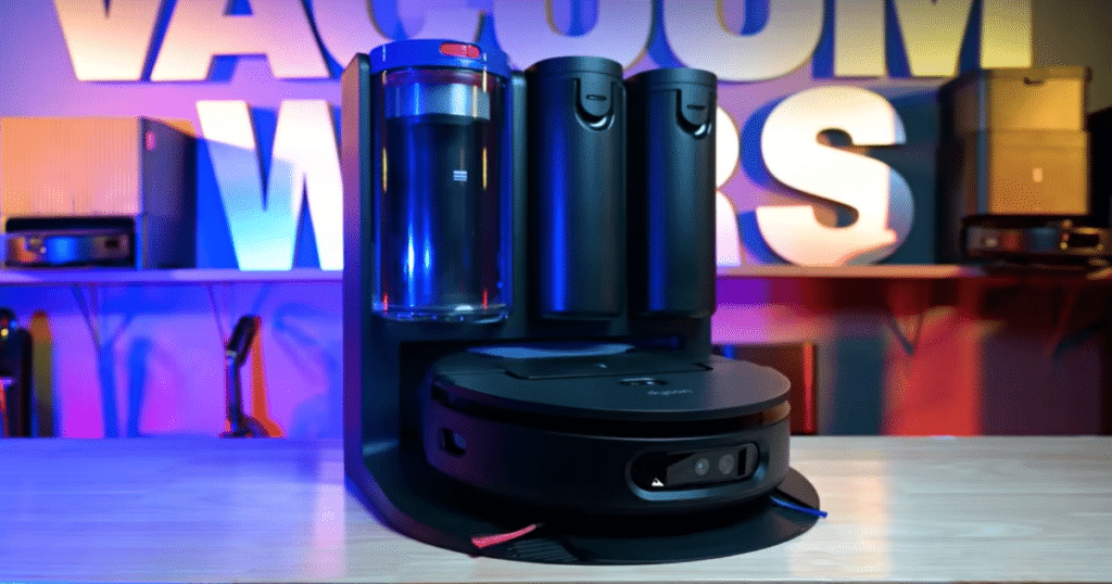 Dyson Spot + Scrub AI hero | Vacuum Wars Robot vacuum with charging dock on a table, illuminated by blue-purple lighting in a tech showroom or studio setting.