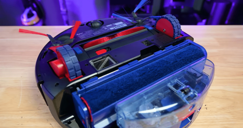 Dyson Spot + Scrub AI mop hardware | Vacuum Wars Underside of Dyson Spot+Scrub AI showing brush roll, side brushes, wheels, and integrated mop hardware affecting vacuum performance