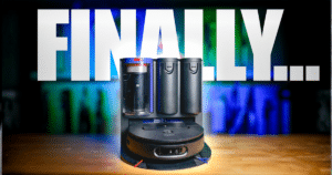Dyson Spot and Scrub AI review | Vacuum Wars Robot vacuum on its dock with a large 'FINALLY...' banner in the background.