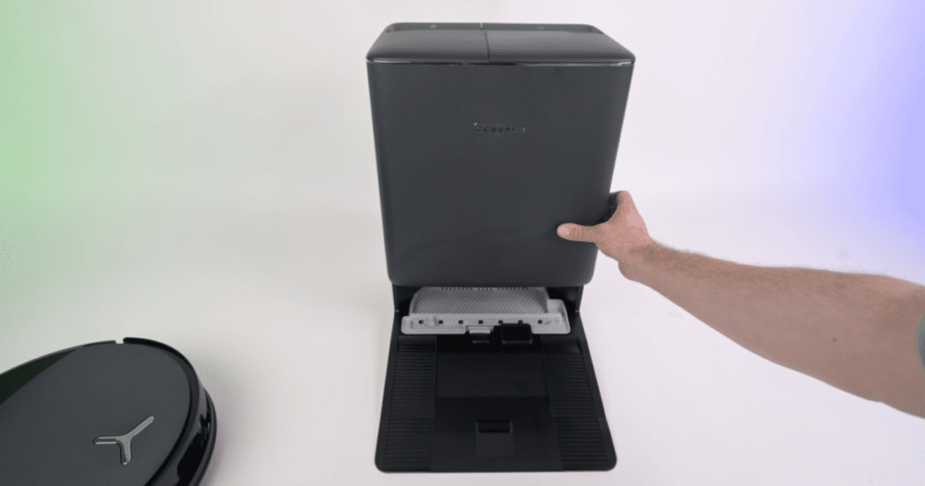 Ecovacs T90 Pro Omni Robot Vacuum automated station | Vacuum Wars Close-up of Ecovacs T90 Pro Omni auto-empty dock with lid open, showing internal dustbin compartment and robot vacuum nearby.