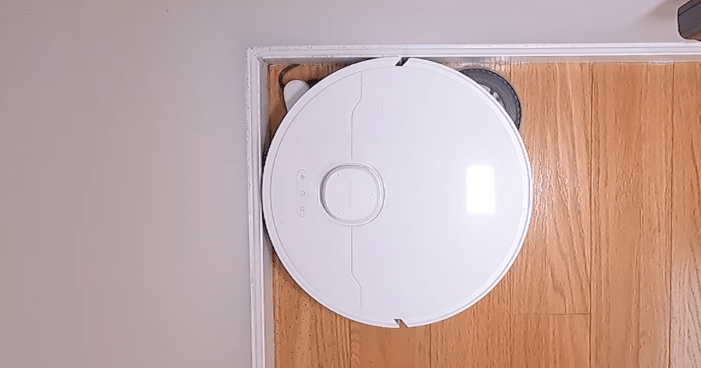 MOVA P10 Pro Ultra Gen 2 extending side brush | Vacuum Wars Top-down view of MOVA P10 Pro Ultra Gen 2 robot vacuum using an extending side brush to clean edges and corners along a wall.