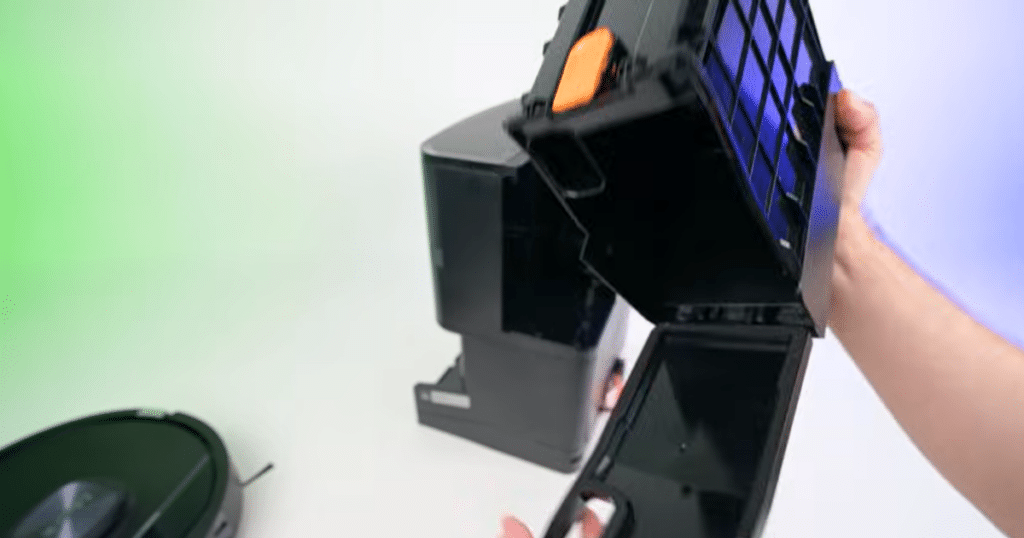 Shark Powerdetect UV Reveal bagless dustbin | Vacuum Wars Shark robot vacuum dock with bagless auto-empty dustbin being opened, showing internal debris compartment without disposable bag.