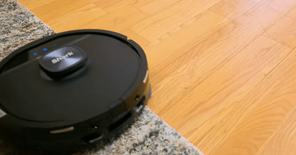 Shark Powerdetect UV Reveal carpet lift | Vacuum Wars Shark robot vacuum transitioning from hard floor to carpet, demonstrating 20 mm mop lift to avoid wetting rugs.