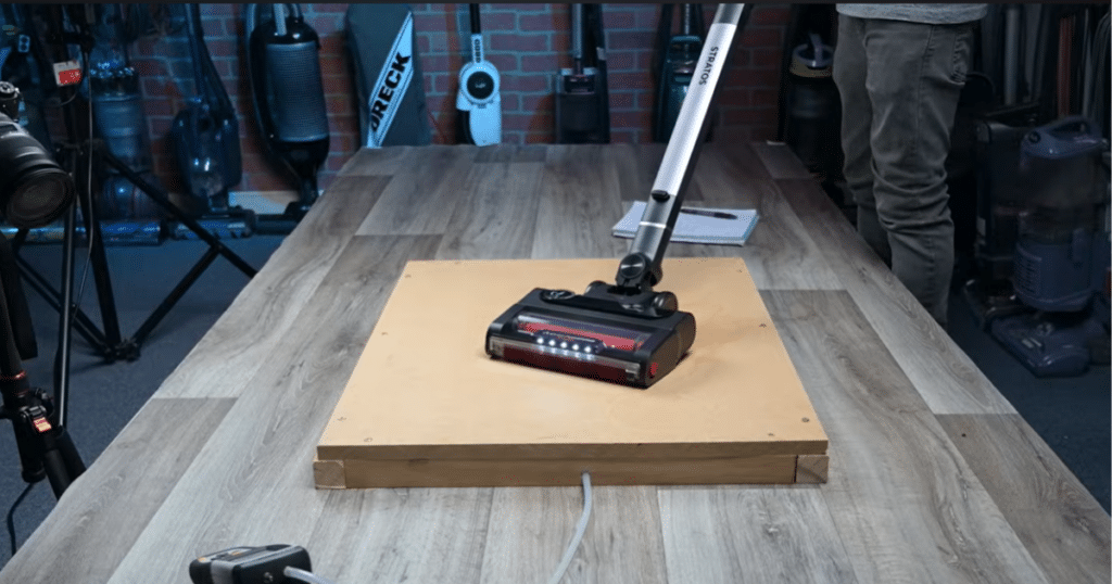 Shark Stratos Power | Vacuum Wars Shark Stratos cordless vacuum performing debris pickup test on a flat surface in a controlled testing environment.