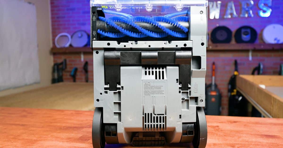 | Vacuum Wars Underside view of the Bissell TurboClean Pet XL showing its 4-Row DeepReach PowerBrush with blue bristles behind the clear brush cover.