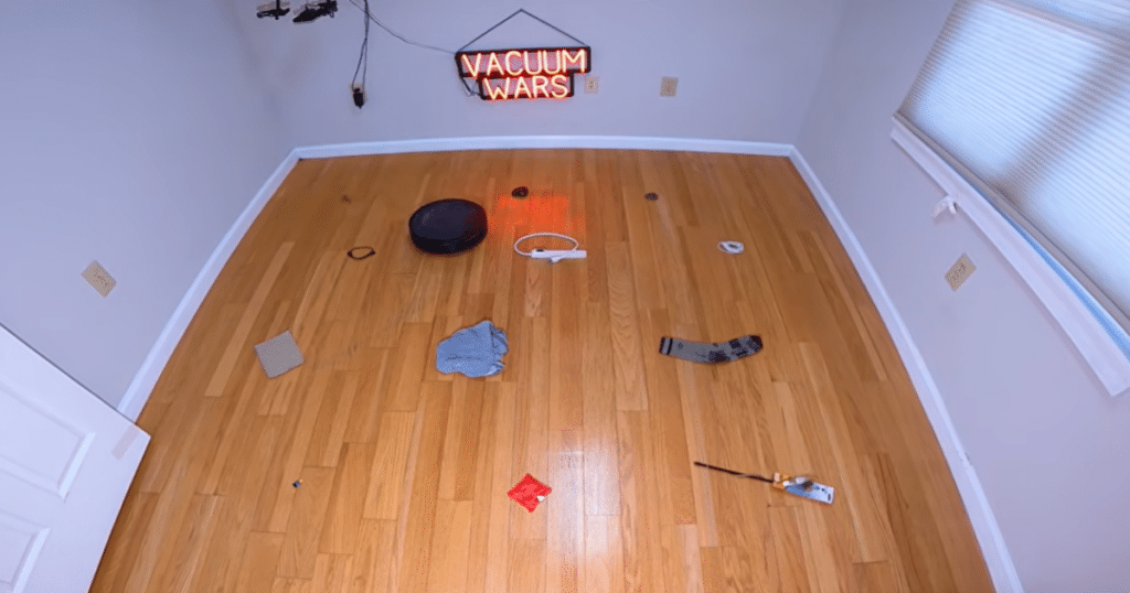 Ecovacs Deebot T90 Pro Omni Obstacle Avoidance | Vacuum Wars Ecovacs T90 Pro Omni robot vacuum navigating a hardwood floor obstacle avoidance test area with common household objects scattered throughout the room.