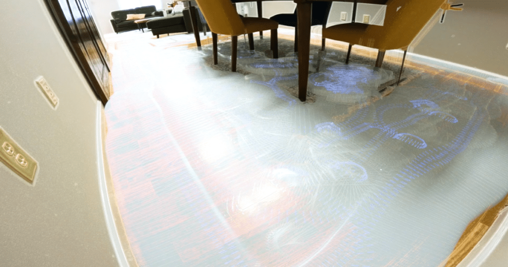 Eufy C28 Navigation 2 | Vacuum Wars Dining room with a dark wood table and yellow chairs on a blue patterned rug; showing the path of the Eufy C28 robot vacuum complete its navigation around the room.