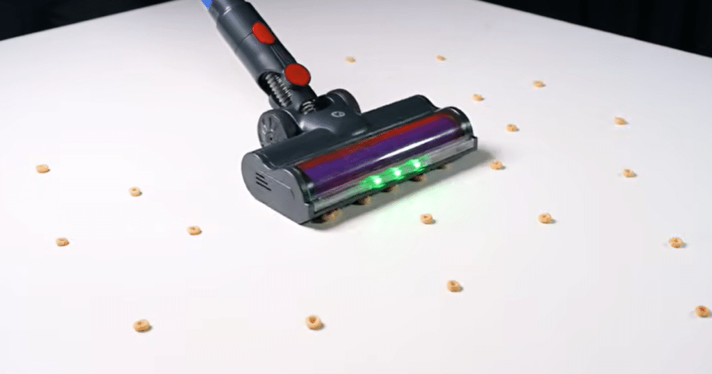 KARDV V06 snowplow | Vacuum Wars The KARDV V06 cordless vacuum floor head pushing larger debris like Cheerios across hard flooring during Vacuum Wars pickup testing, illustrating limited large debris intake due to the low-profile floor head design.