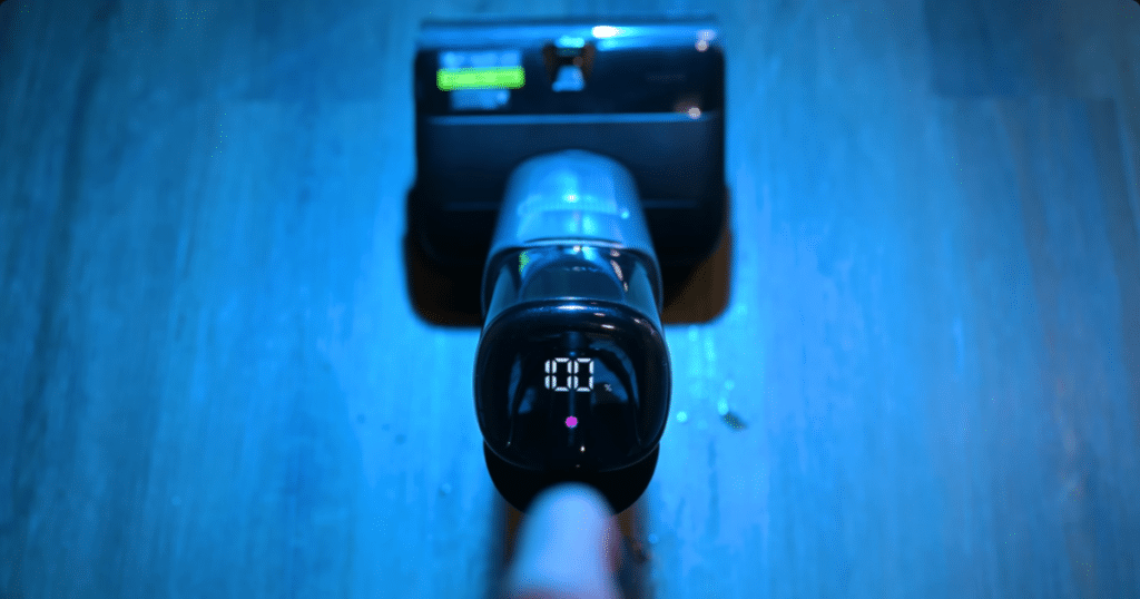 MOVA X4 Display | Vacuum Wars Top-down view of the MOVA X4 Pro cordless floor cleaner showing its LED display illuminated while operating on a hard floor surface.