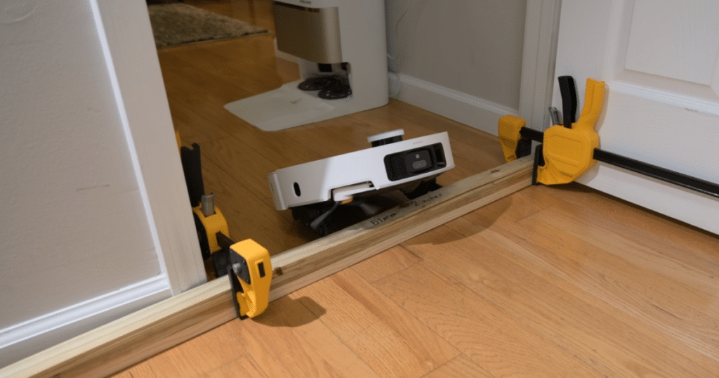 Dreame L60 Pro Ultra robot vacuum crossing a 51 mm threshold during Vacuum Wars' threshold-climbing test, compared to the Dreame L50 Ultra's 25 mm result