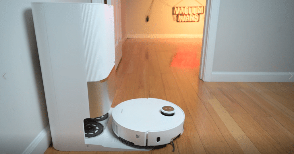Dreame L60 Pro Ultra robot vacuum docked at its multifunction station featuring automatic dustbin emptying, hot-water mop washing, hot-air drying, detergent mixing, and automatic mop pad removal
