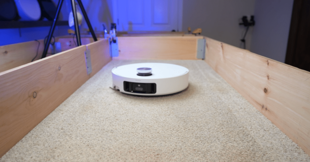 Dreame L60 Pro Ultra robot vacuum performing Vacuum Wars' carpet deep-cleaning test on medium-pile carpet