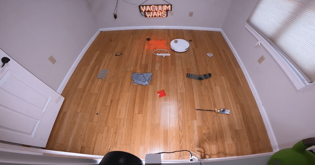 Dreame L60 Pro Ultra robot vacuum navigating Vacuum Wars' obstacle avoidance test course with common household objects