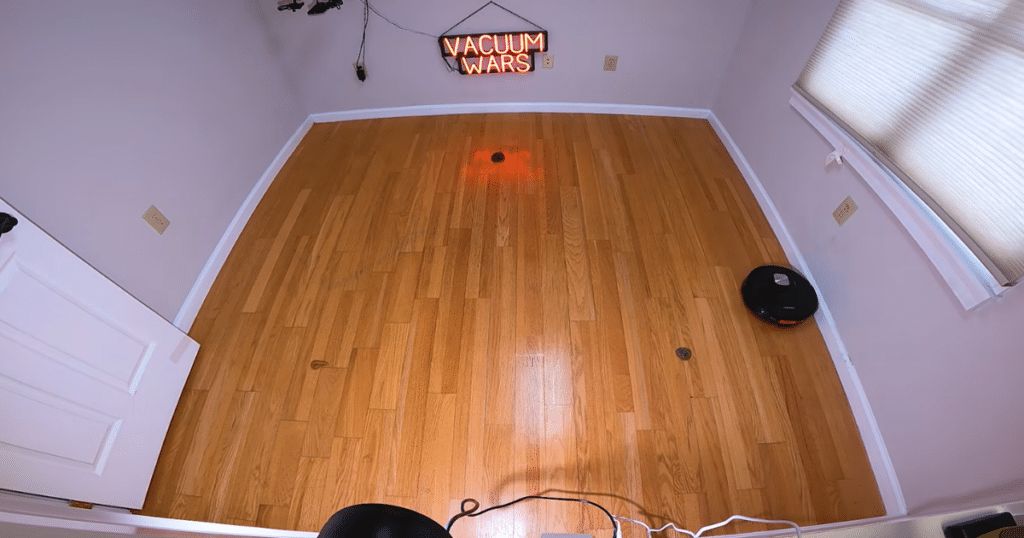 MAMNV D13S Max no obstacle avoidance | Vacuum Wars MAMNV D13S Max robot vacuum navigating a hardwood floor test area with small objects placed on the floor to evaluate obstacle avoidance.