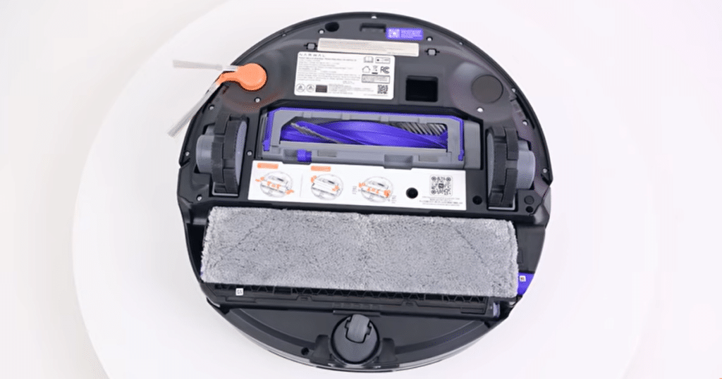 Narwal Flow 2 mop | Vacuum Wars Underside view of the Narwal Flow 2 robot vacuum showing its rolling-track mop system, anti-tangle main brush, side brush, and self-cleaning mopping assembly that continuously refreshes with 140°F (60°C) hot water and collects dirty water in an onboard tank.