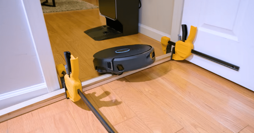 Narwal Flow 2 threshold | Vacuum Wars Narwal Flow 2 robot vacuum climbing a raised threshold during testing, demonstrating obstacle-crossing performance on a 32 mm and 38 mm doorway threshold, exceeding typical robot vacuum clearance capabilities.