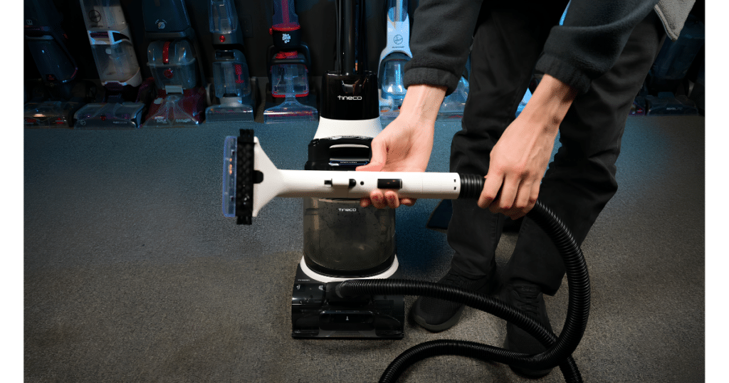 Tineco Carpet ONE Cruiser Hose at the Vacuum Wars Studio 1 | Vacuum Wars Tineco Carpet ONE Cruiser carpet cleaner with hose and handheld attachment connected for above-floor cleaning in the Vacuum Wars studio.