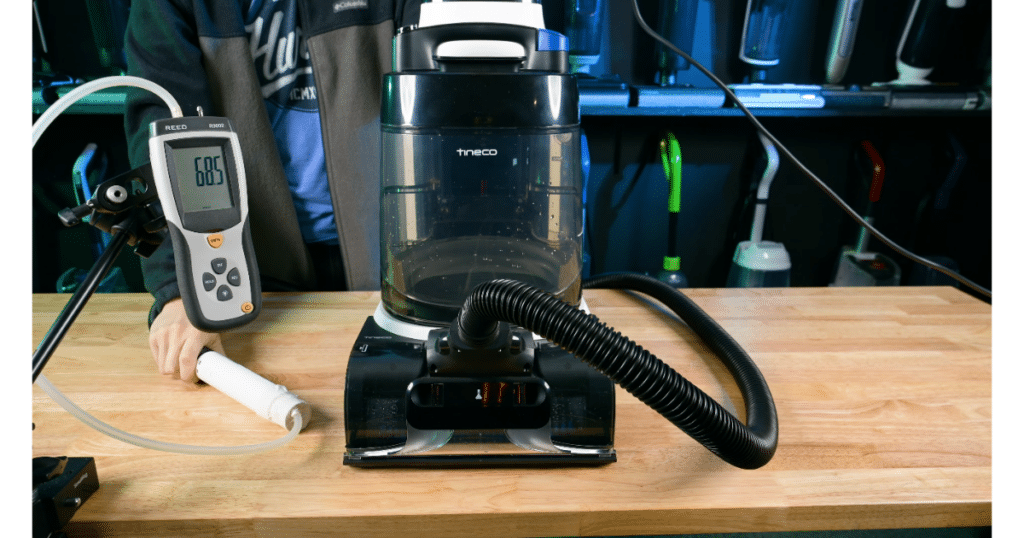 Tineco Carpet ONE Cruiser Measuing Sealed Sution at the Vacuum Wars Studio | Vacuum Wars Tineco Carpet ONE Cruiser connected to suction testing equipment in the Vacuum Wars studio, with a meter measuring sealed suction at the hose.