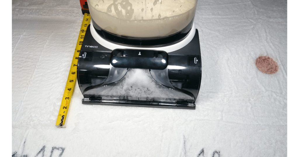 Tineco Carpet ONE Cruiser Stain Tests at Vacuum Wars | Vacuum Wars Tineco Carpet ONE Cruiser cleaning a dried grape juice stain on white carpet during Vacuum Wars stain testing, with foam visible in the cleaning path.