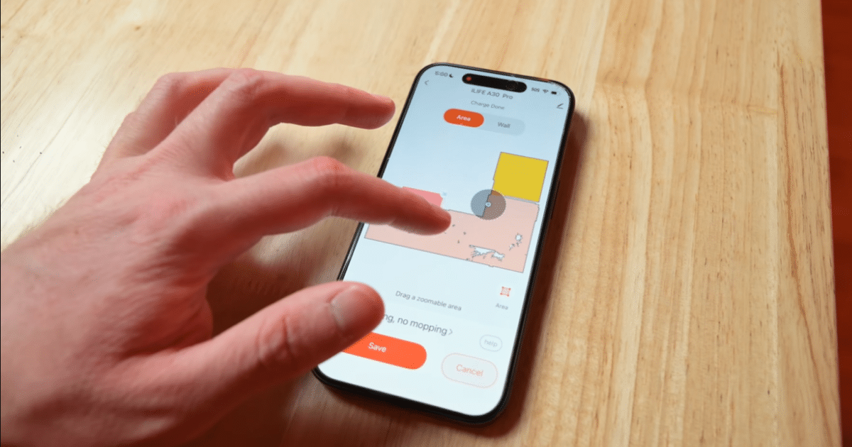 Hand using the iLife Home mobile app on a smartphone to view and manage a robot vacuum's cleaning map and settings.