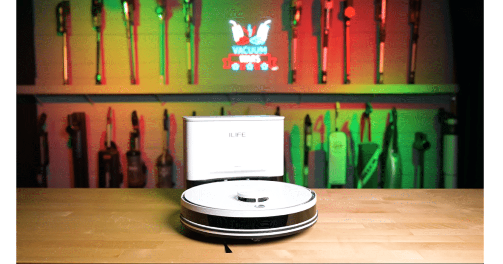 iLife A30 Pro Robot Vacuum at the Vacuum Wars Studio | Vacuum Wars The iLife A30 Pro robot vacuum and auto-empty dock displayed in the Vacuum Wars test studio, with a wall of vacuum cleaners in the background.