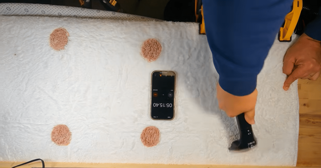 Bissell Little Green Mini Cordless spot cleaner stain removal testing at Vacuum Wars | Vacuum Wars Vacuum Wars stain-removal evaluation showing dried grape juice stains on white carpet being scrubbed with the Bissell Little Green Mini Cordless Tough Stain Tool.