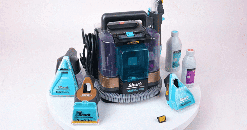 Shark StainStriker product | Vacuum Wars Shark StainStriker HairPro portable spot cleaner with included attachments and cleaning solutions displayed during Vacuum Wars testing. The portable carpet cleaner achieved the highest stain reduction score we have recorded and includes four cleaning attachments with a dual-solution cleaning system.