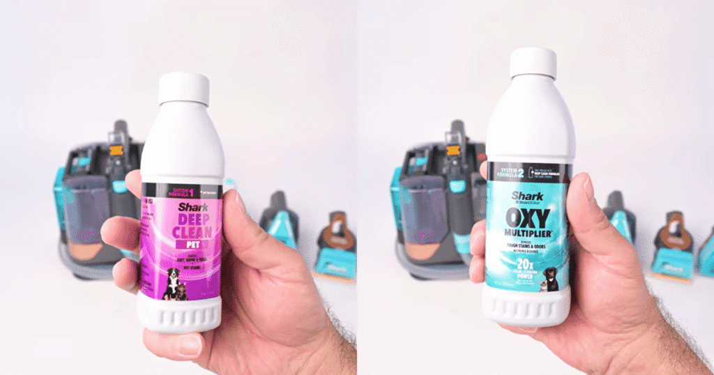 Shark StainStriker solution | Vacuum Wars Shark StainStriker HairPro handle and hose connection shown alongside the included cleaning solutions during Vacuum Wars testing. The portable spot cleaner includes 18 ounces of cleaning solution, compared with the 9.6-ounce category average.